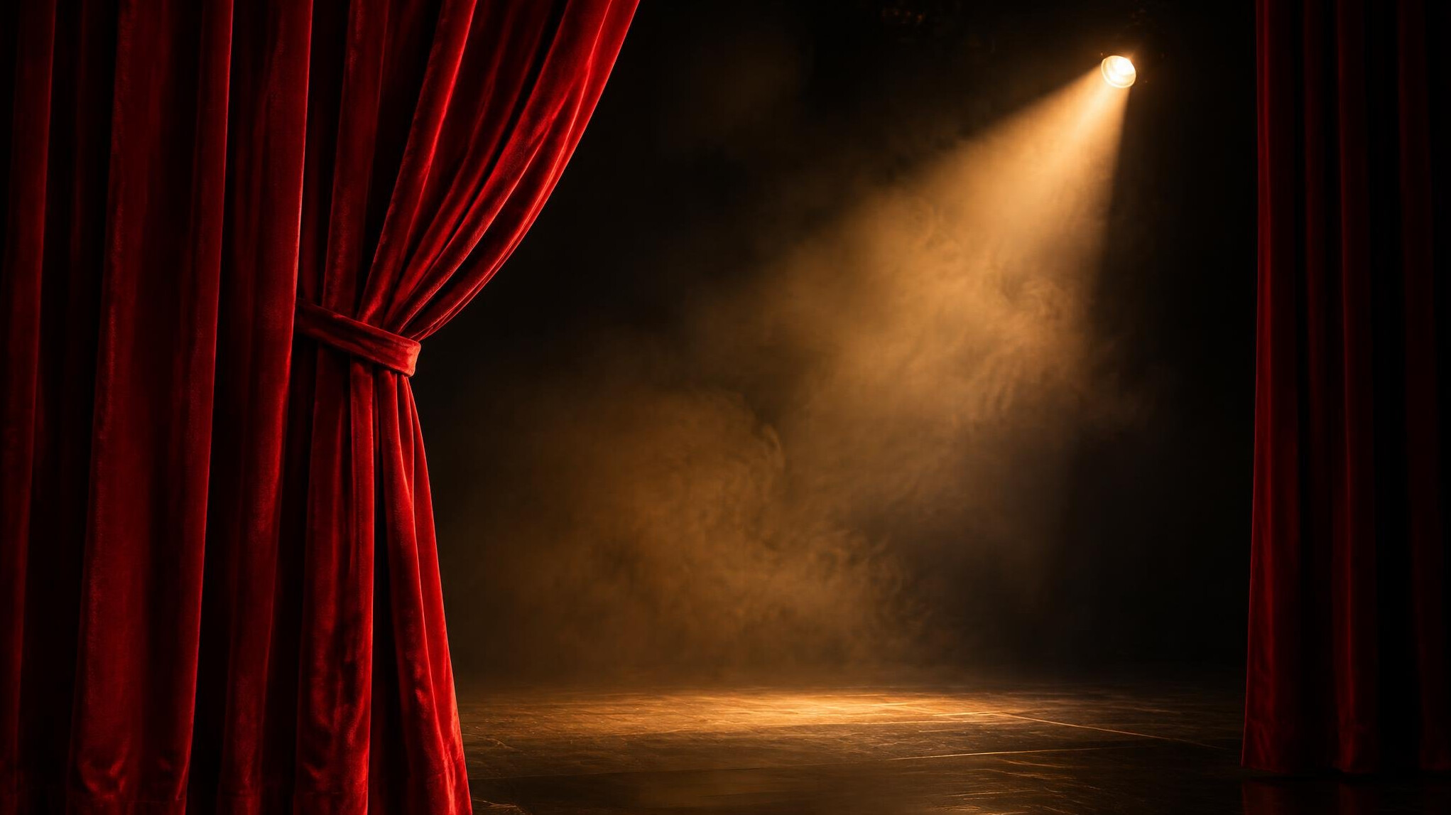 Dramatic theater stage curtain with warm spotlight glow